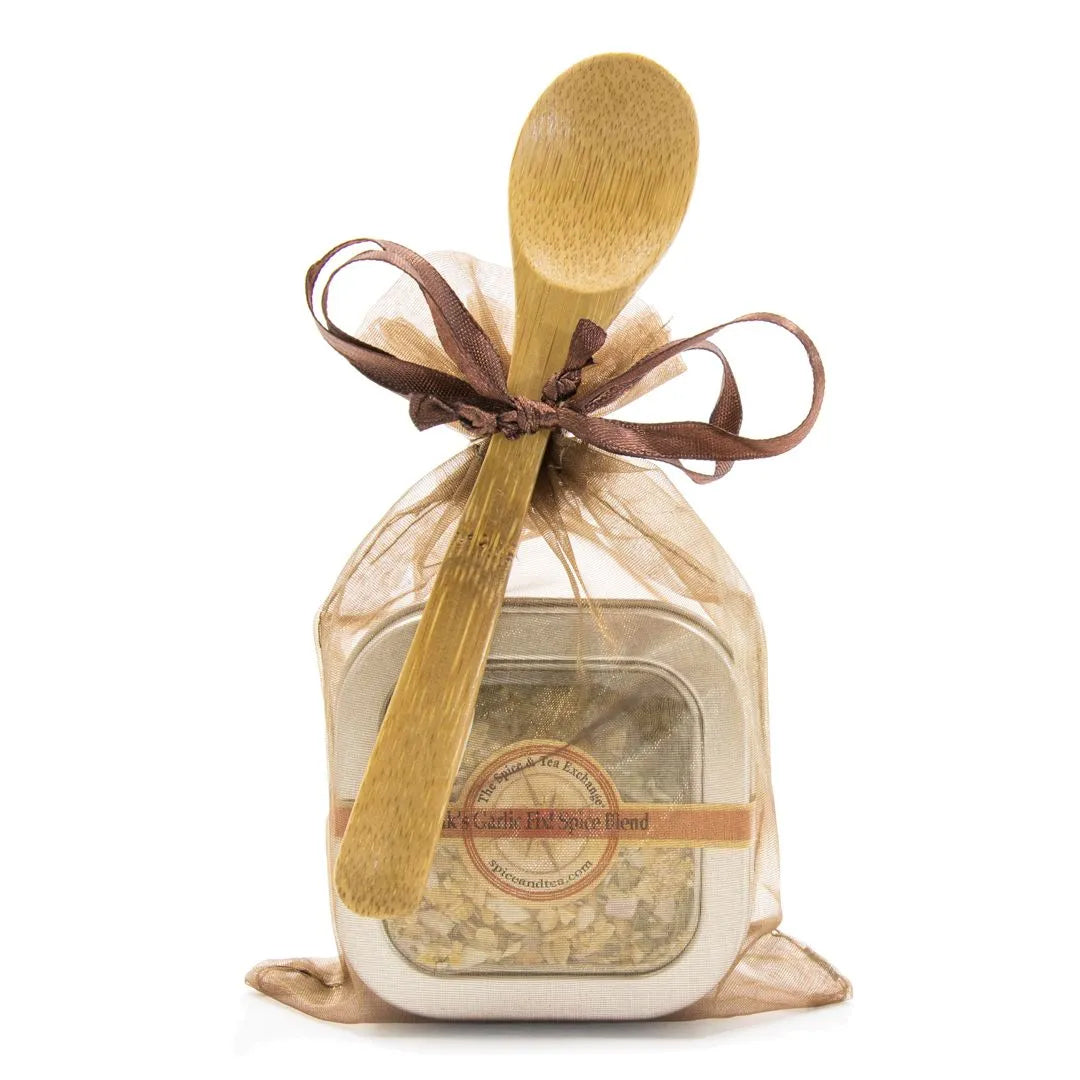 Vik's Garlic Fix Spice Blend comes in a spice tin with an attached bamboo spoon, wrapped in a sheer gold organza bag and tied with a brown ribbon—perfect for gifting or adding flavor to any meal.