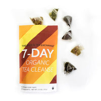 The 7 Day Organic Tea Cleanse features a colorful package and seven pyramid sachets of premium organic teas, all arranged on a white background for an inviting cleanse experience.