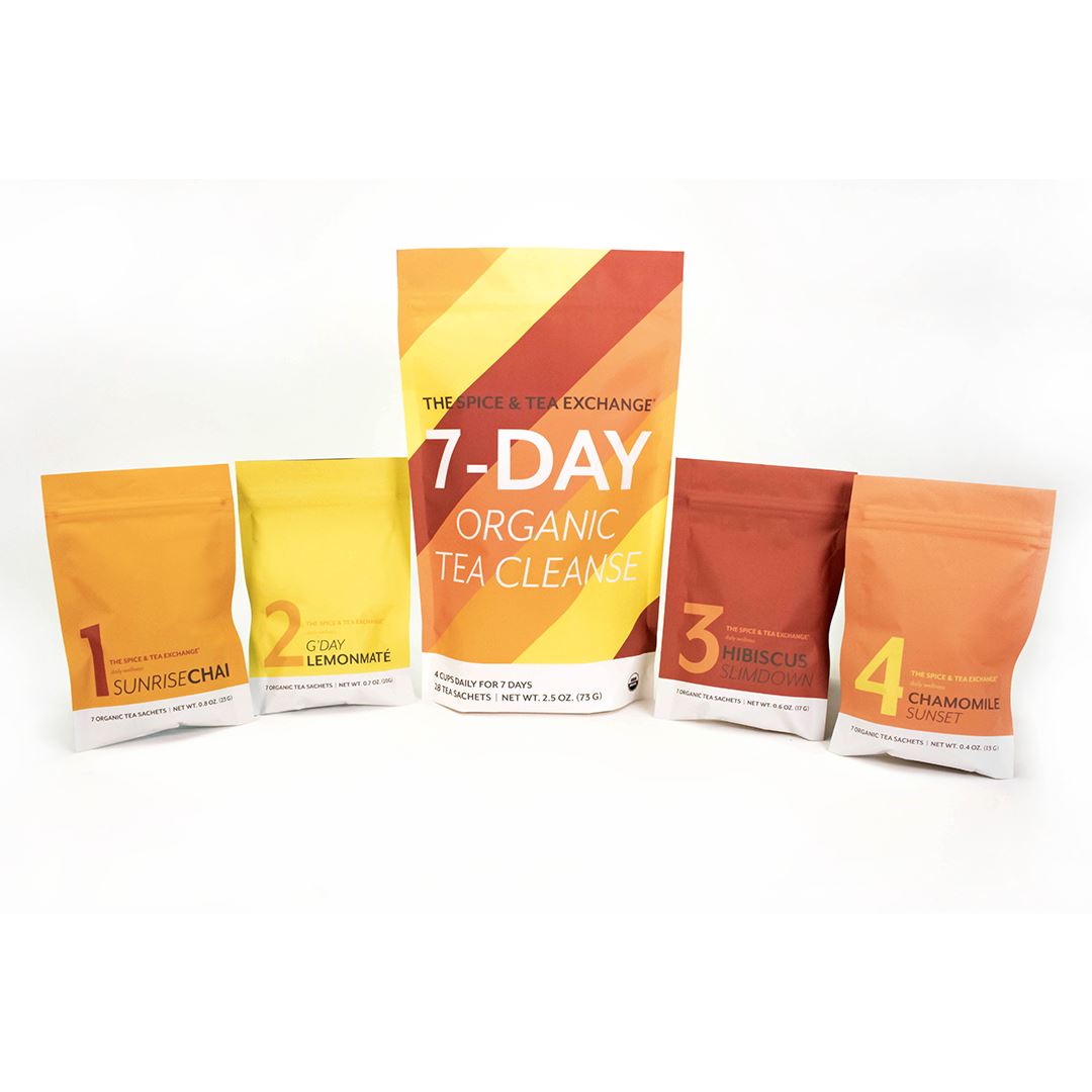 Five vibrant tea packages are arranged in a row. The largest center bag displays “7 Day Organic Tea Cleanse,” while four smaller, colorful bags surround it, each featuring unique wellness teas marked with blend numbers.