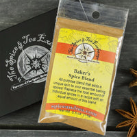 A packet of Baker's Spice Blend - Barter Box, an all-purpose baking spice, sits atop a black box with The Spice & Tea Exchange logo. The scene is accented by a nearby star anise, making it a perfect gift for baking enthusiasts.
