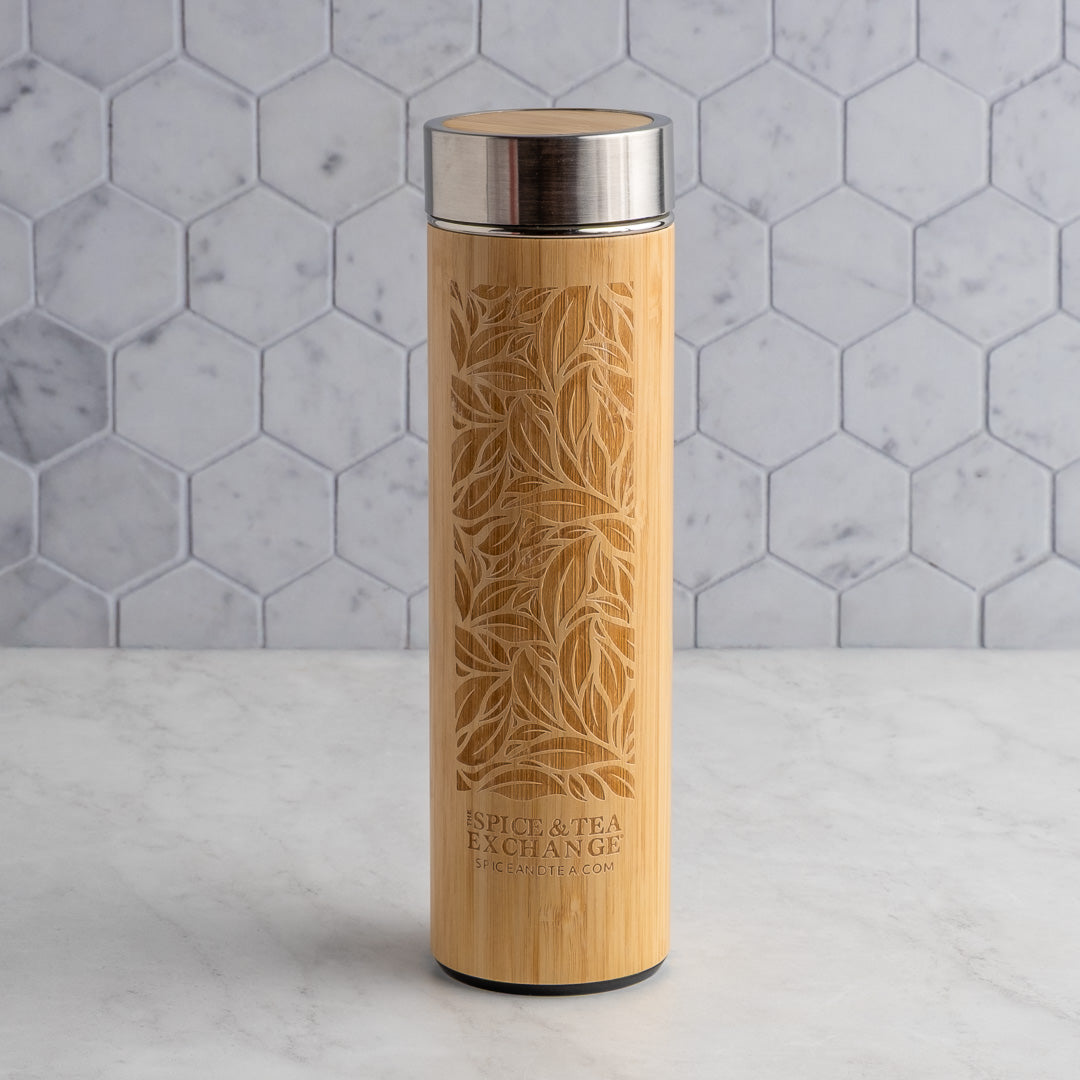 Bamboo Leaf Travel Tumbler with silver lid on a marble surface with hexagonal tile backsplash
