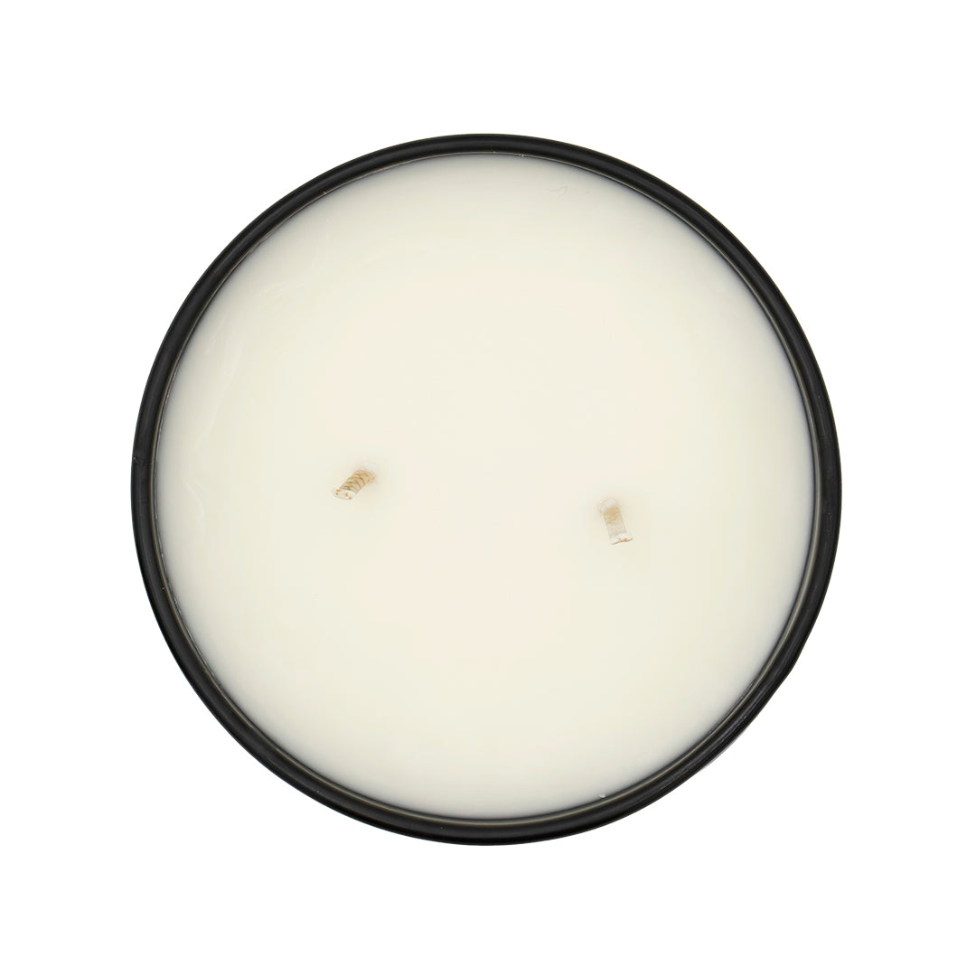Round white candle in a black container on a white background