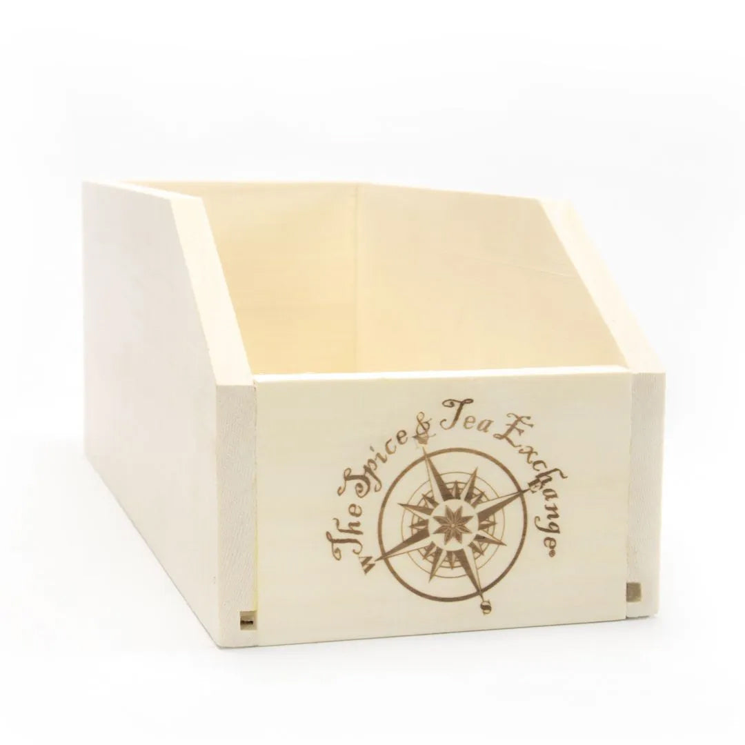 The Small Branded Wood Storage Box is crafted from poplar wood with an open top, slanted sides, a compass design, and "The Spice & Tea Exchange" engraved—ideal for storing spices or organizing your favorite teas.