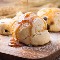 Honey drizzled over biscuits on a wooden surface