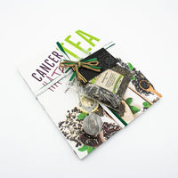 The Cancer Hates Tea Book & Bundle - Marrakesh Mint features the book, Marrakesh Mint Tea, and a metal infuser, beautifully arranged on a white background to celebrate tea and wellness.