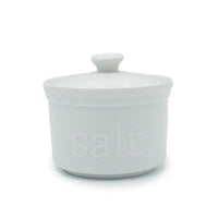 The White Ceramic Salt Cellar features a matching lid and "salt" embossed on the front, ideal for storing artisan salts and adding style to your kitchen storage.
