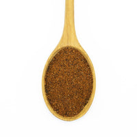 A wooden spoon filled with finely ground Light Chili Powder, brownish-red in color, viewed from above against a white background.