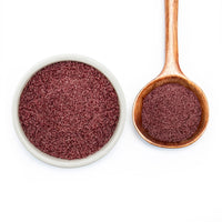 Cranberry Orange Monk Fruit Sweetener in white bowl and on wooden spoon
