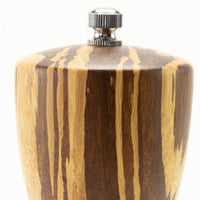 Close-up of the top of the 8" Crushed Bamboo Pepper Mill with a metal knob, highlighting its natural wood grain and striped light and dark brown bamboo pattern.