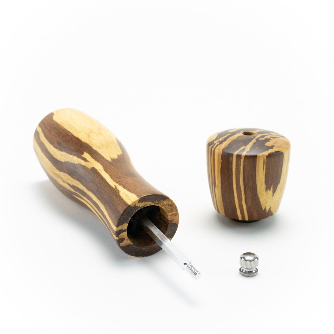 The 8" Crushed Bamboo Pepper Mill features a wooden handle, detachable cap, thin metal rod, and small metal coil and ring—set against a white background. It's an ideal unique kitchen gift or addition to your organic pepper mill collection.