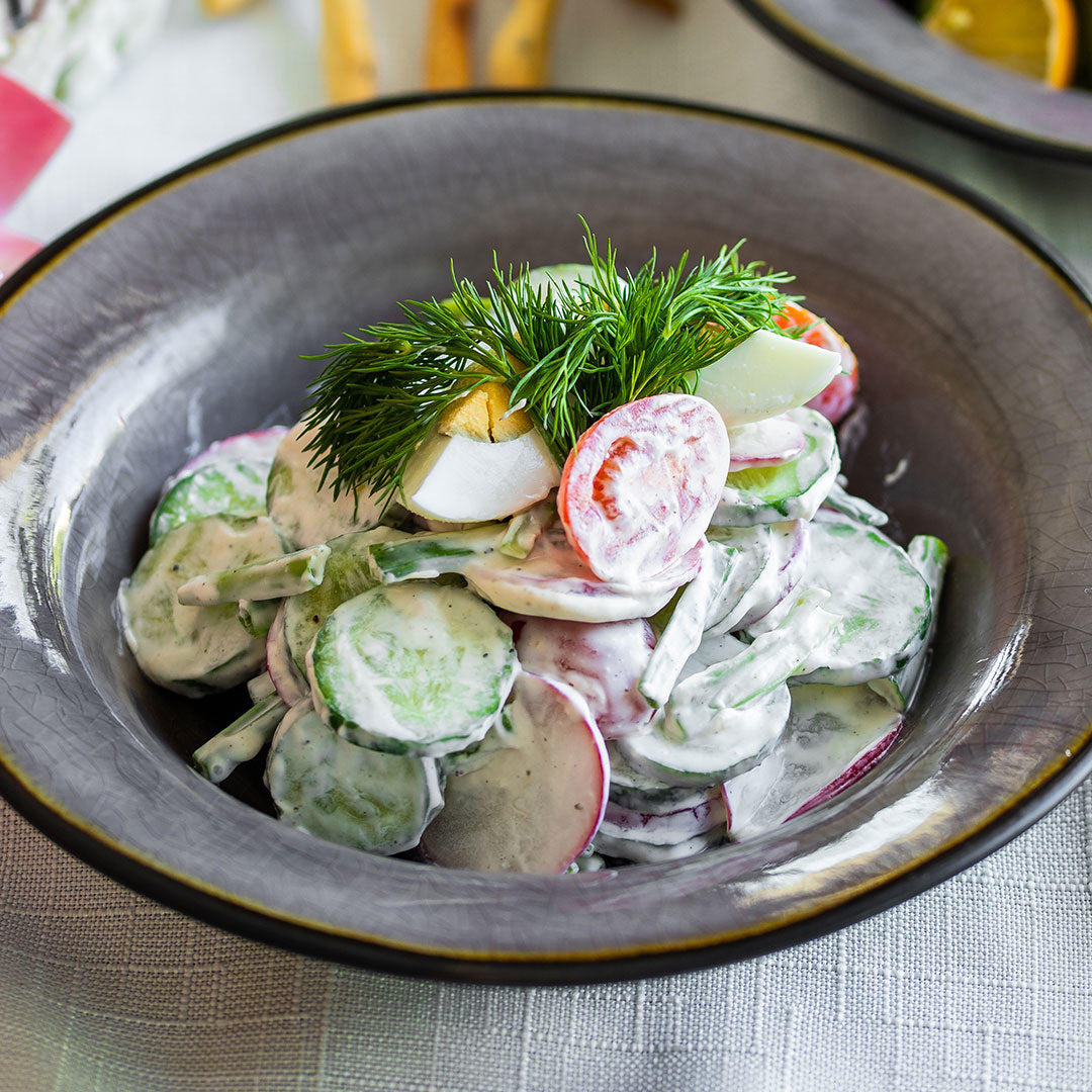 Creamy cucumber and radish  salad with dill tomatoes and hard boiled eggs on top