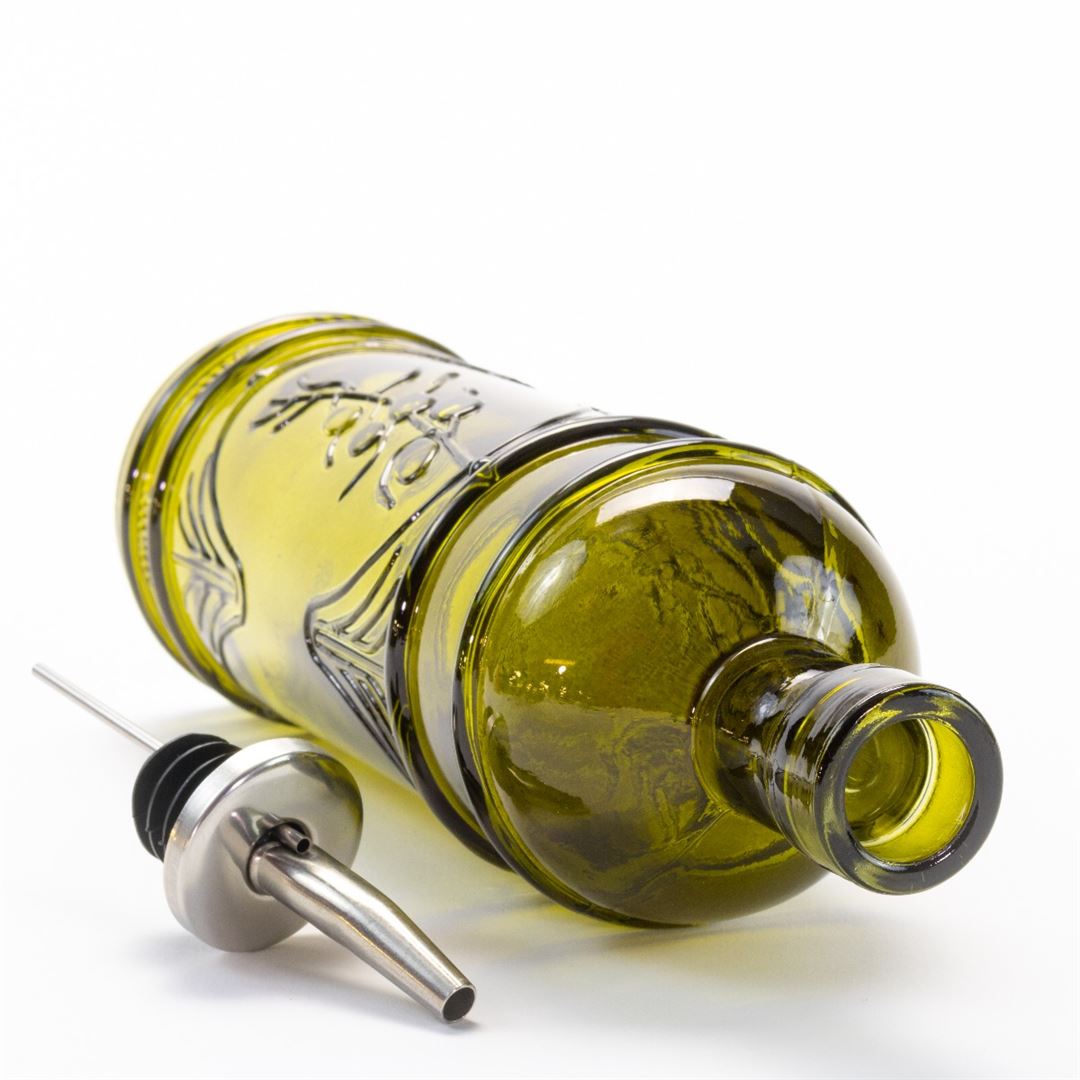 The Olive Glass Oil Jar, crafted from green glass, lies on its side with its metal pour spout removed and placed nearby on a white background.