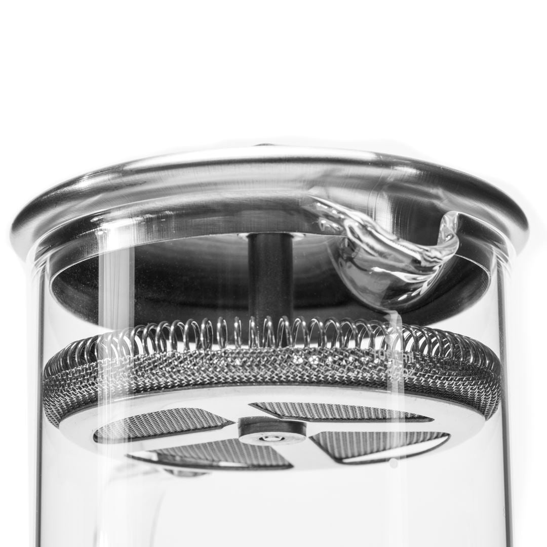 Close-up view of the top section of the Glass Pitcher with Filter, showing a metal lid, pouring spout, and stainless steel filter inside the glass container—ideal for brewing loose-leaf teas.
