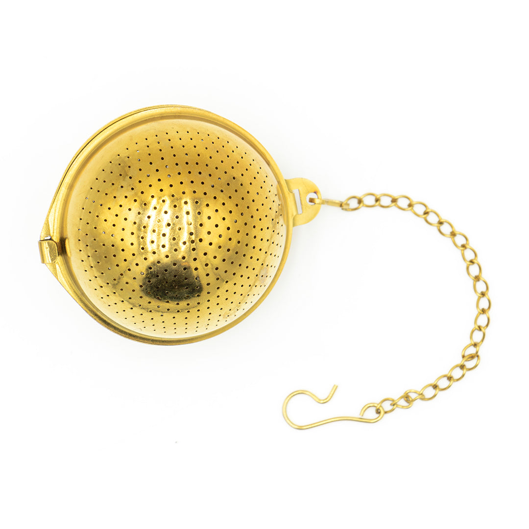 The Gold Ball Infuser - Small is a round gold stainless steel tea infuser with fine holes, a clasp opening, and a short chain with hook for securing to your cup or teapot, displayed on a white background.