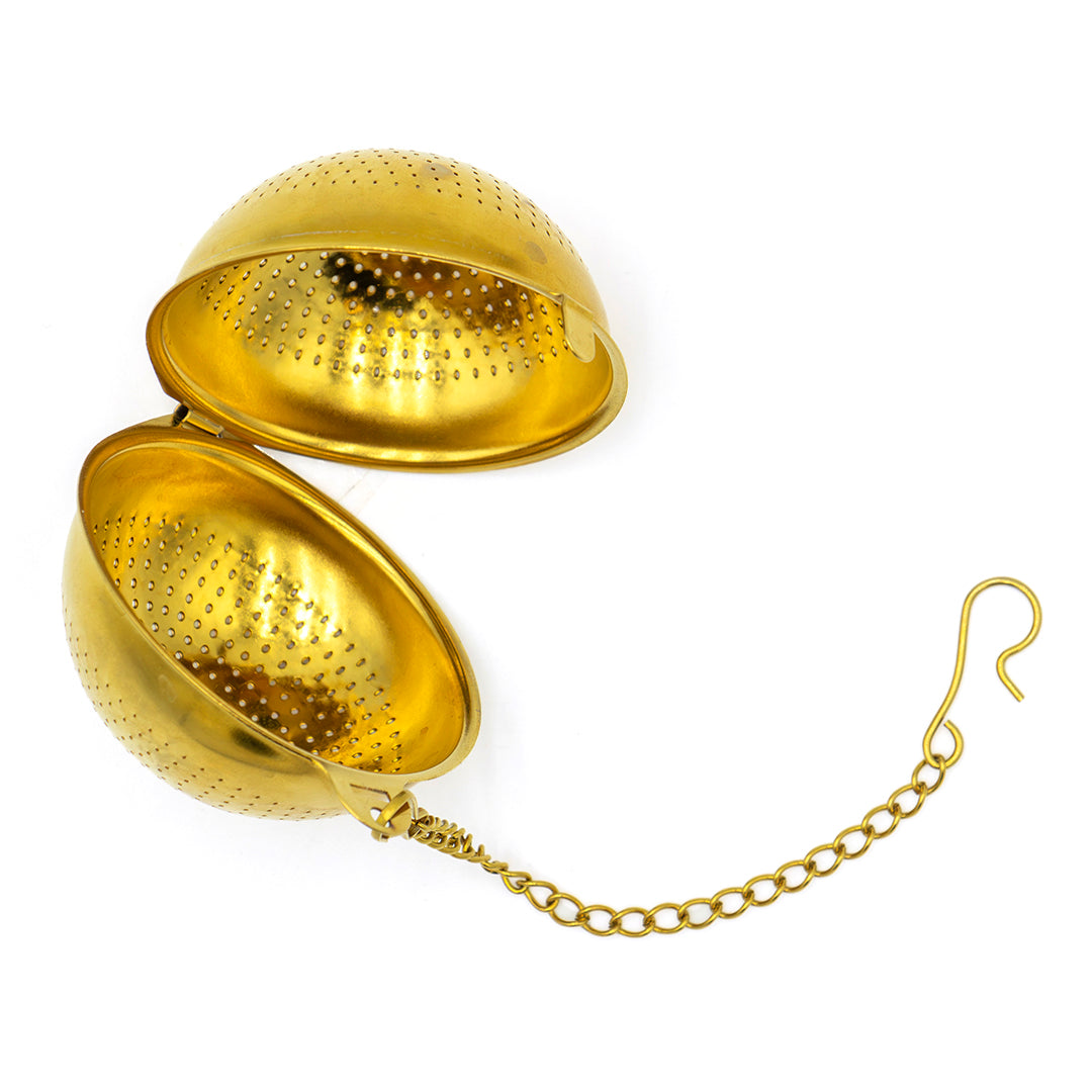 The Gold Ball Infuser - Small is a stylish metal tea infuser featuring perforated gold halves connected by a hinge, plus a chain and hook for easy removal from your cup or teapot—ideal for tea lovers.
