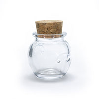 The Glass Jar Honey Pot with Cork, featuring a round clear body and cork lid, sits against a plain white background—ideal for storing spices or displaying small treasures.