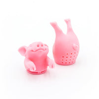 Two Hot Belly Infuser tea strainers—pink, BPA-free silicone pig shapes (one with head/front legs, one with hind legs)—stand on a white background. Each has holes for steeping your favorite loose leaf tea.