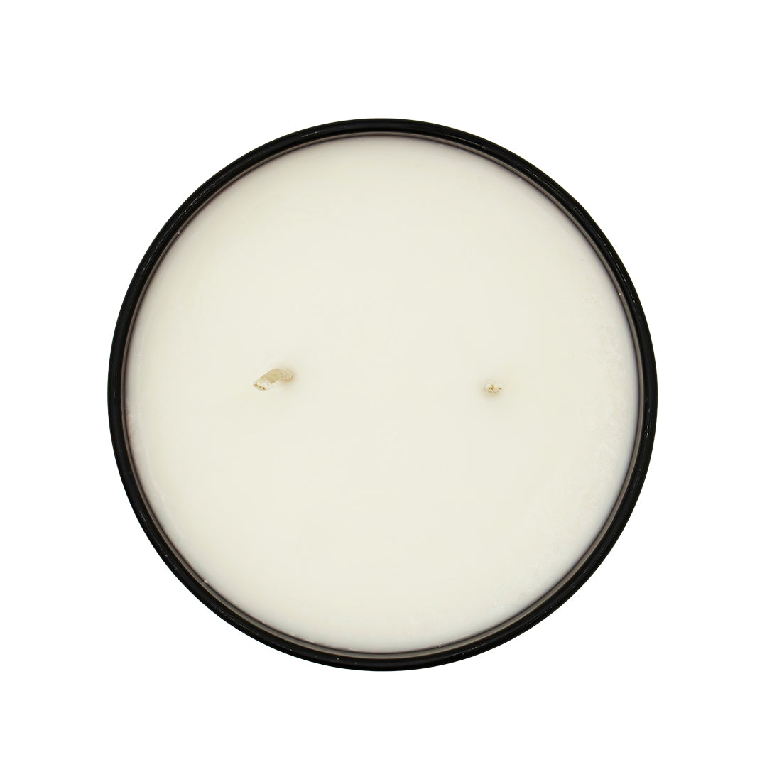 Round candle in a black container on a white background