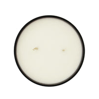 Round candle in a black container on a white background