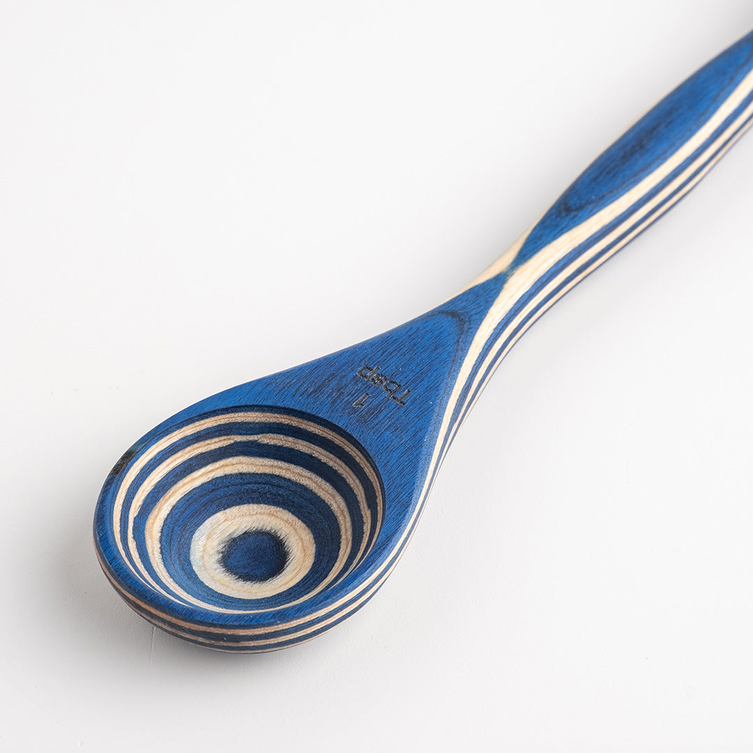 Wooden spoon with blue and beige spiral pattern on a white background