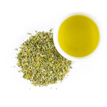 A pile of Organic Catnip for pets sits beside a white cup containing yellow-green liquid, all arranged on a plain white background.