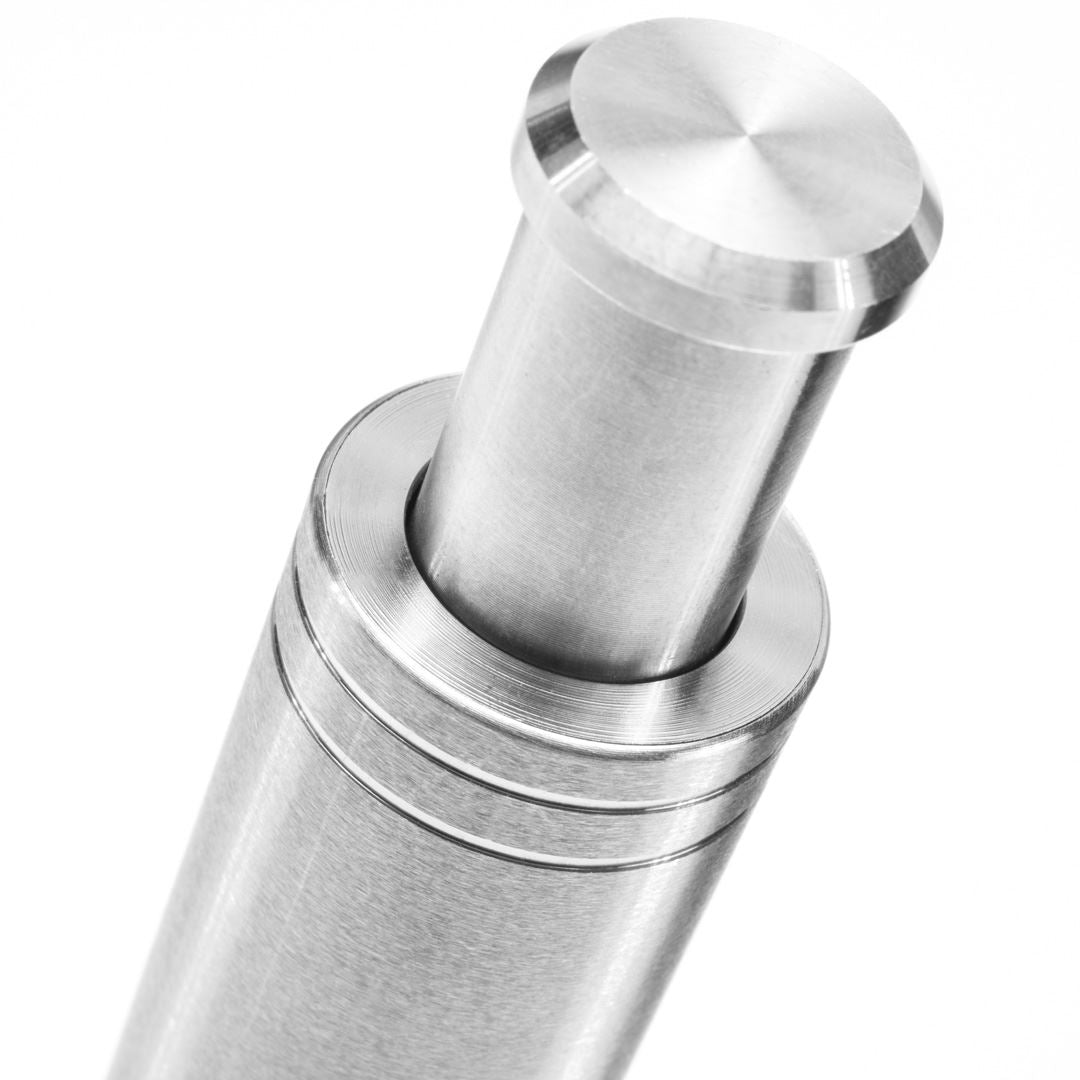 Close-up of the Pump & Grind Salt & Pepper Mill—a compact stainless steel cylinder with a polished finish, a round protruding top, and grooved rings near the upper section—photographed against a white background.