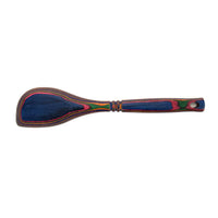 The Rainbow Corner Spoon is a moisture-resistant wooden spatula with a rounded flat blade and a handle crafted from layered blue, red, green, and yellow pakkawood. It includes a hole at the end for easy hanging.