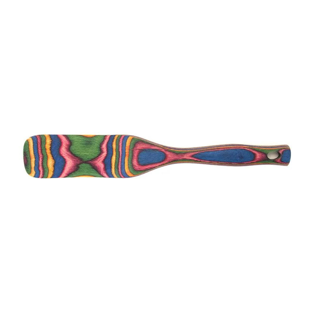 The Rainbow Spurtle is a durable kitchen utensil with a flat blade and a vibrant, layered handle in green, pink, blue, yellow, and orange pakkawood; the handle also has a convenient hole near the end.