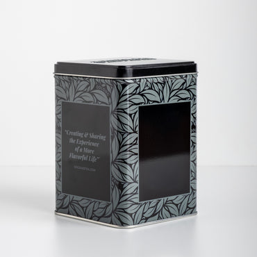 Decorative black grey and silver tea tin with leaf pattern on a white background. With text: Creating & Sharing the Experience of a More Flavorful Life spiceandtea.mom