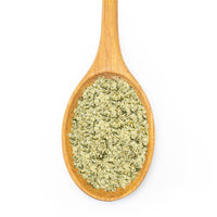 A wooden spoon filled with greenish, finely ground French Fry Seasoning - Salt 'n Vinegar, isolated on a white background.