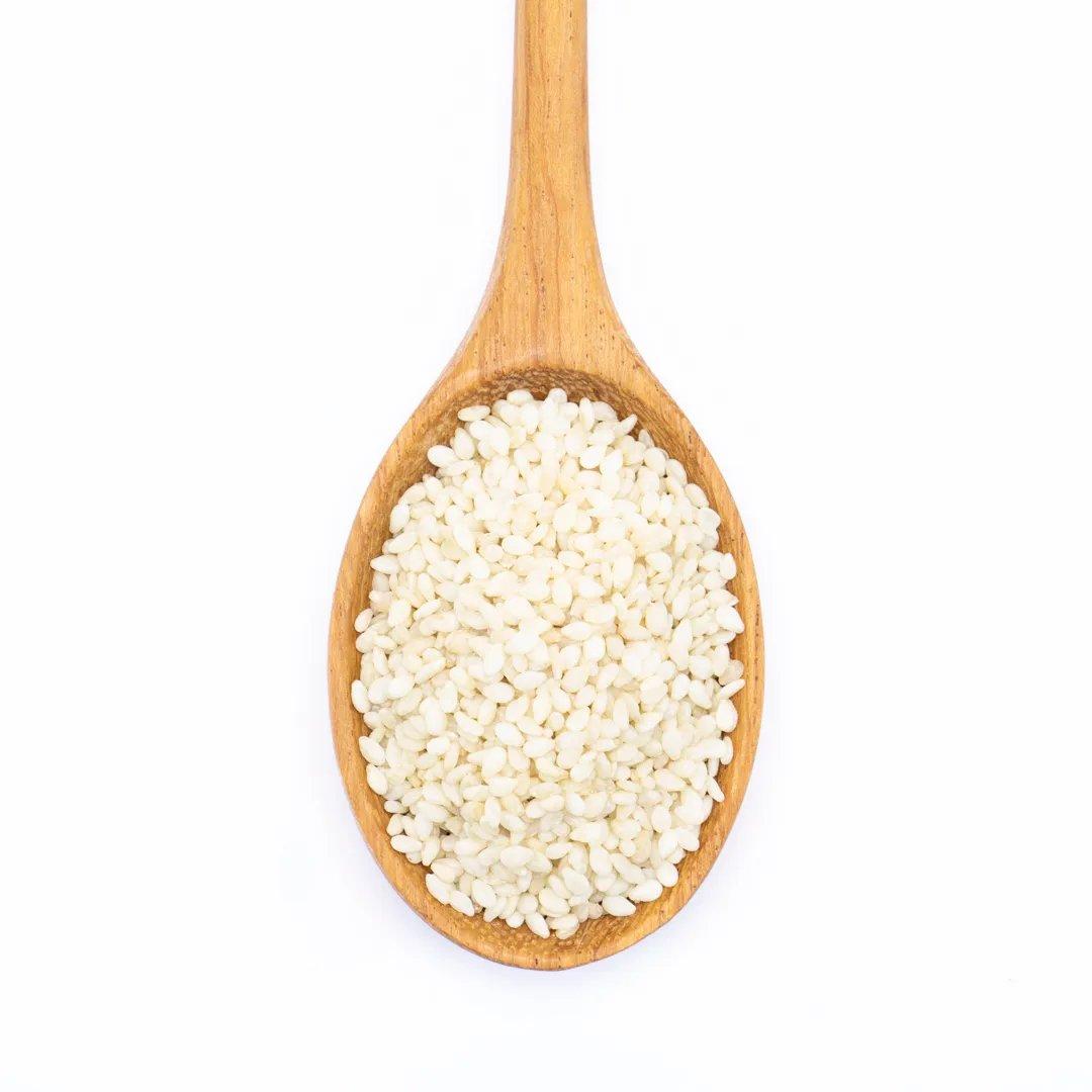 A wooden spoon filled with Sesame White Seed, a staple in Asian cuisine, displayed on a white background.