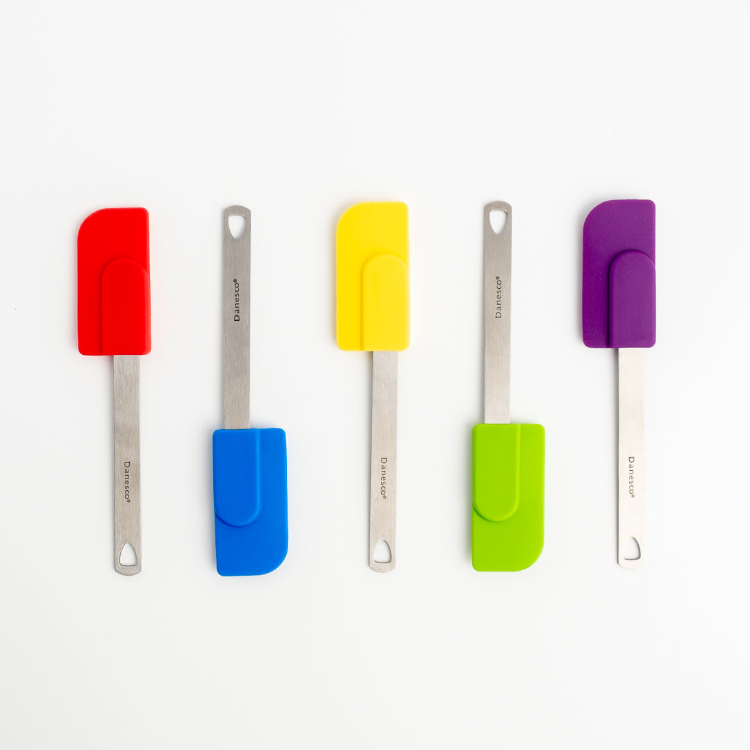 Five Mini Spatulas with stainless steel handles and small silicone heads in red, blue, yellow, green, and purple are arranged vertically on a white background—ideal for any kitchen.