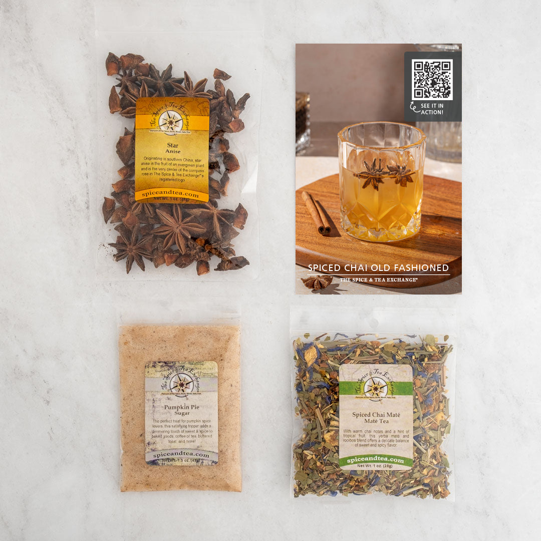 Top-down view of the Spiced Chai Old Fashioned (Kit), featuring three spice packs—star anise, pumpkin pie spice, and spiced chai mint tea—plus a recipe card, all arranged on a light surface.
