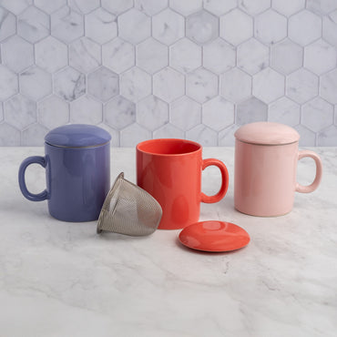 Three mugs in blue, red, and pink with various lids on a marble surface.