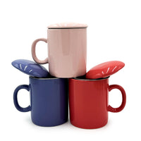 Set of three colorful mugs with lids on a white background