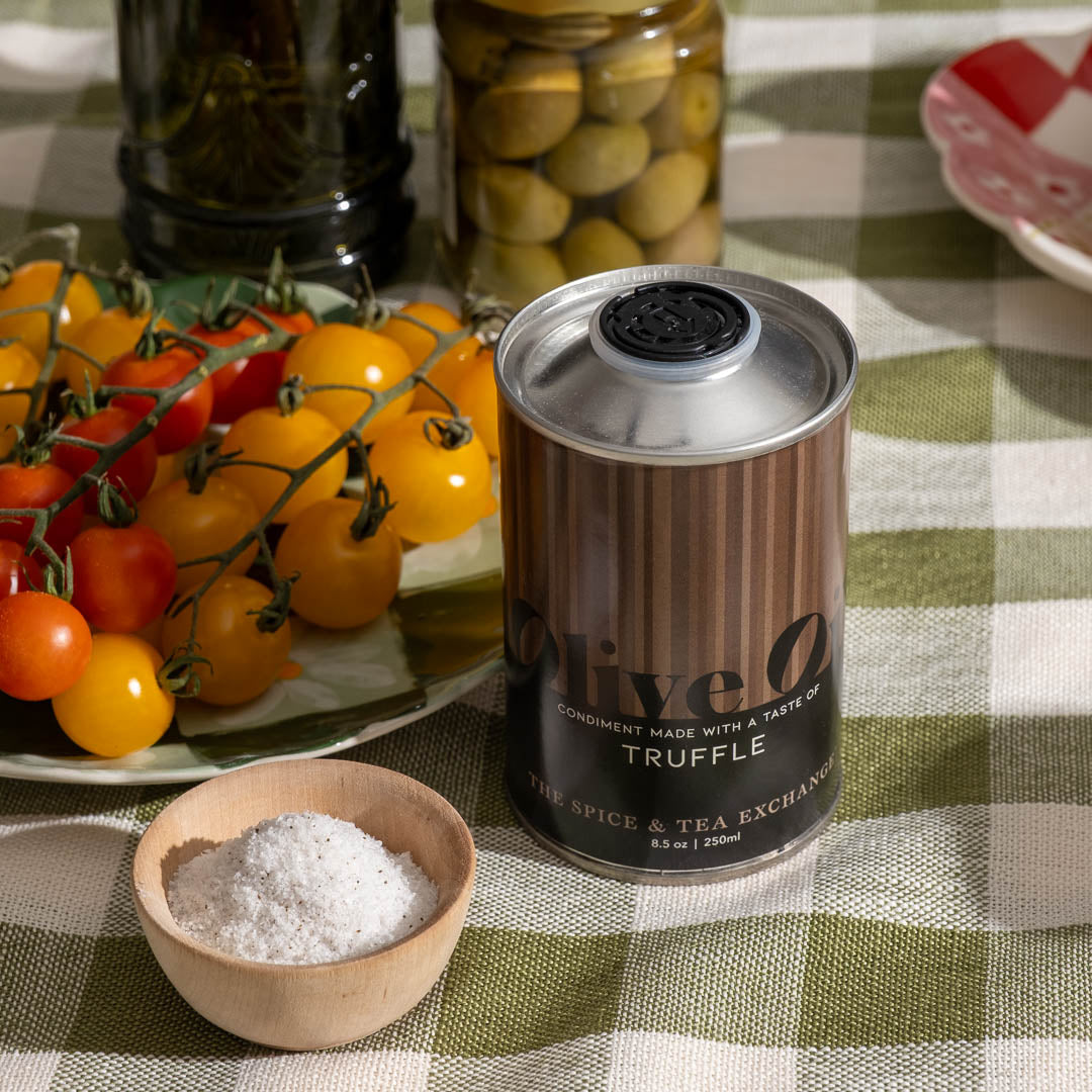 Truffle Extra Virgin Olive Oil next to bowl of salt, colorful mini tomatoes, and olives