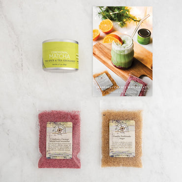 The Cranberry Orange Matcha Latte (Kit) includes a ceremonial matcha tin, recipe card for a Cranberry Orange Matcha Latte, plus cranberry orange and vanilla turbinado sugar packets—perfect for delightful homemade matcha drinks.
